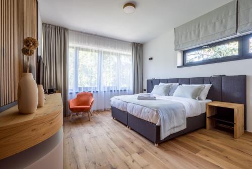 a bedroom with a large bed and a orange chair at Vista Resort & Club in Prague