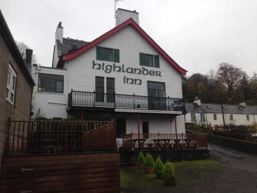 a large white building with a sign on the front of it at Highlander Inn in Craigellachie