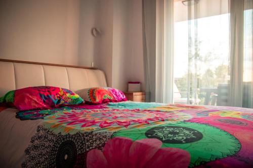 Una cama con una manta colorida y almohadas. en Hisa dobrega pocutja, en Kozina