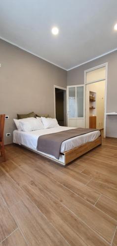 nuova vicinissima alla spiaggia في تيراسيني: سرير كبير في غرفة نوم مع أرضية خشبية