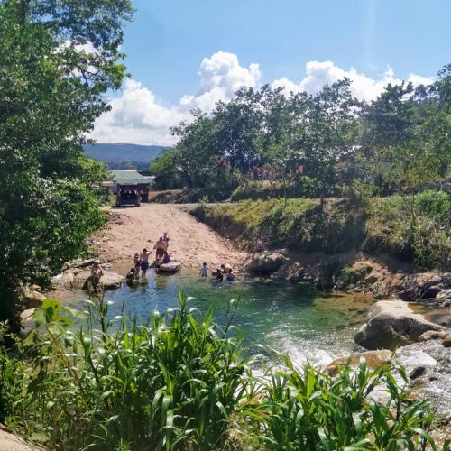 a group of people swimming in a river at Finca de la Vaca - Glamping in Palora