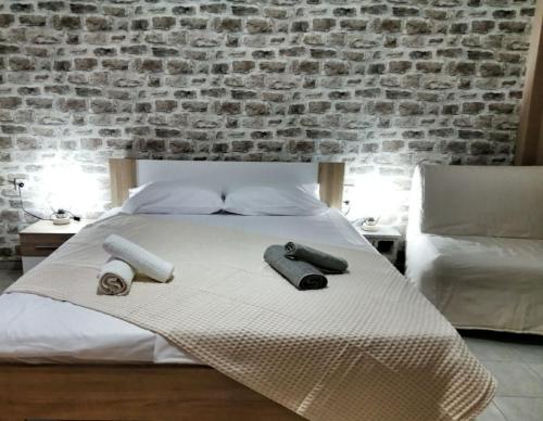 a bedroom with a bed with two pillows and a brick wall at Waterway view in Galatas