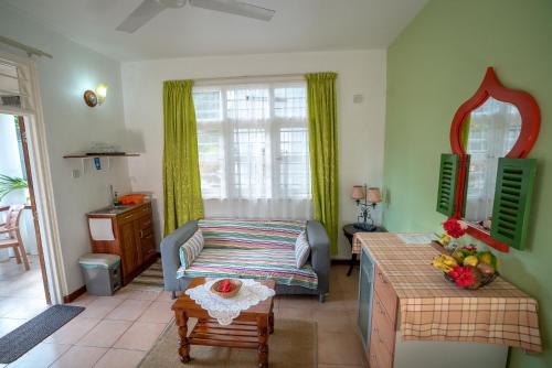 a living room with a couch and a table at La Maison Hibiscus Self Catering Accommodation in Beau Vallon