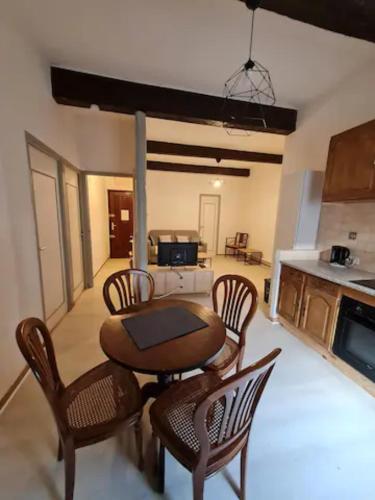un salon avec une table et des chaises et une cuisine dans l'établissement Charming authentic apartment in central location, à Sète
