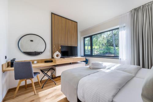 a bedroom with a bed and a desk and a mirror at Vista Resort & Club in Prague