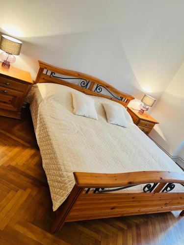 a bedroom with a wooden bed with two lamps at Apartman Lulu 2 in Sarajevo