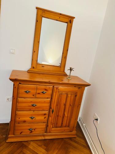 a wooden dresser with a mirror on top of it at Apartman Lulu 2 in Sarajevo
