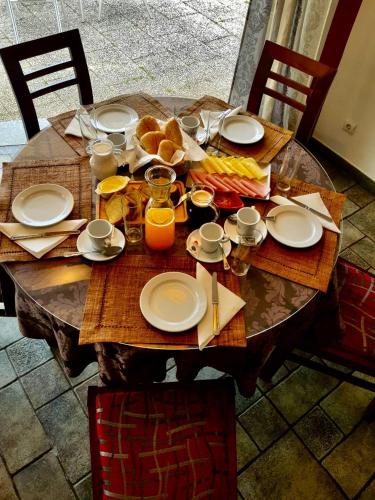 a wooden table with plates of food on it at Moira - Alojamento Local in Reguengos de Monsaraz