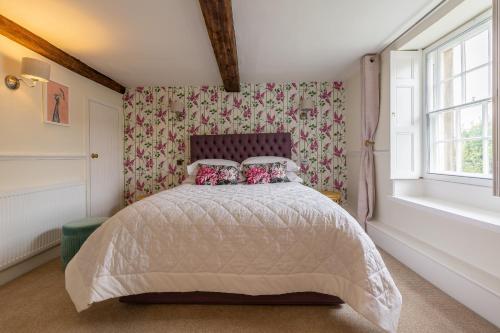 a bedroom with a bed with a white comforter at Grade II Listed House near Chatsworth in Great Rowsley