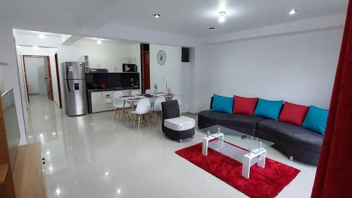 uma sala de estar com um sofá e uma mesa em Departamentos amoblados en Huánuco em Huánuco