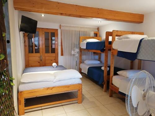 BocapánにあるHospedaje PILARES DE BOCAPANの二段ベッド3台、薄型テレビが備わる客室です。