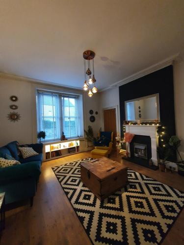 ein Wohnzimmer mit einem Sofa und einem Tisch in der Unterkunft The Flat with the Pink Door in Edinburgh