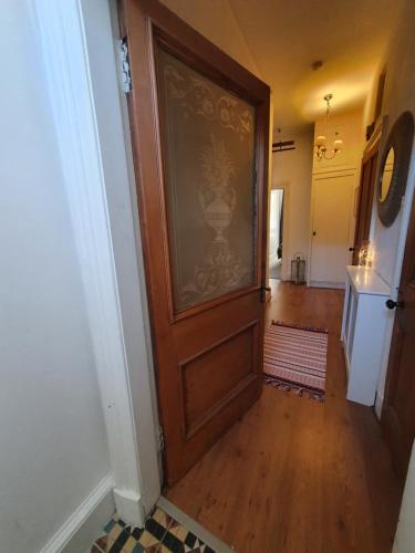 a hallway with a wooden door in a house at The Flat with the Pink Door in Edinburgh