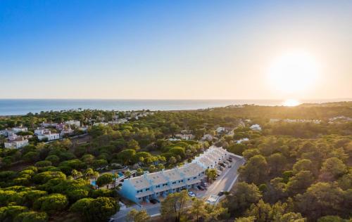 an aerial view of a resort with trees and the ocean at Ancão Gardens in Quinta do Lago