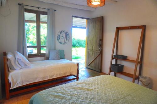 a bedroom with two beds and a mirror and a window at Venao Surf Lodge in Playa Venao