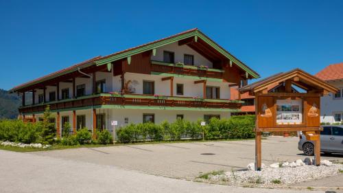 a large building with a sign in front of it at Aparthotel Chiemgaufuchs - CHIEMGAUKARTE in Inzell