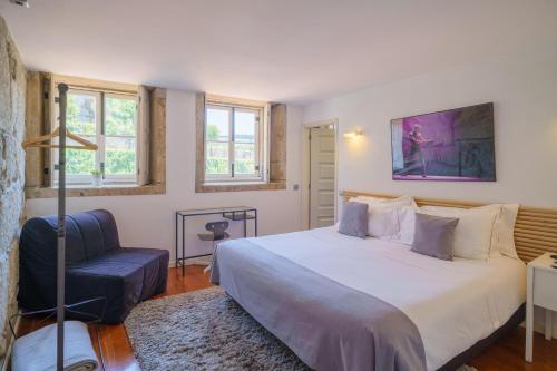 1 dormitorio con 1 cama grande y 1 silla en Feel Porto Ribeira Vintage Duplex, en Oporto