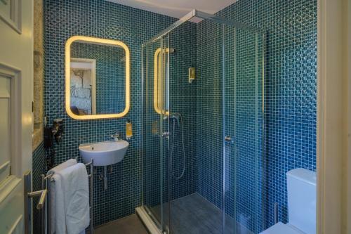 y baño de azulejos azules con lavabo y ducha. en Feel Porto Ribeira Vintage Duplex, en Oporto