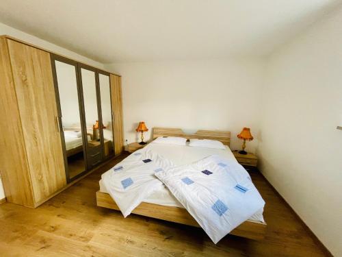 um quarto com uma cama com lençóis brancos em Moderne Ferienwohnung am Rothsee em Hilpoltstein
