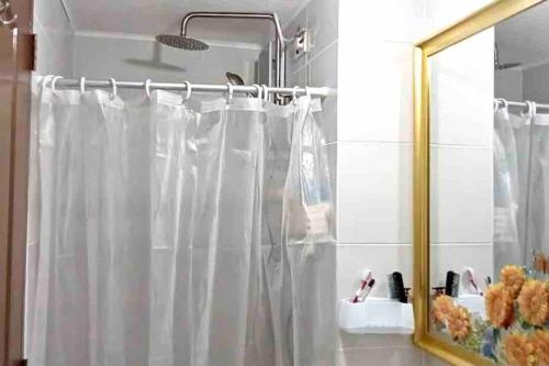 bagno con tenda per la doccia e specchio di Dreamy 2BR condo, with a golf course view a Cebu City