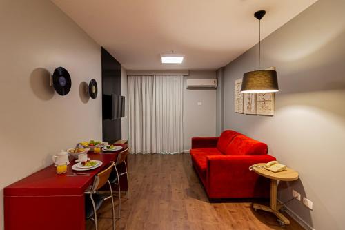 a living room with a red couch and a table at Lobie Queen Ipanema in Rio de Janeiro