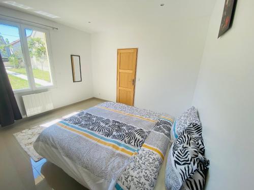 ein Schlafzimmer mit einem Bett mit Kissen darauf in der Unterkunft Maison proche de Paris/CDG et Disney in Villeparisis