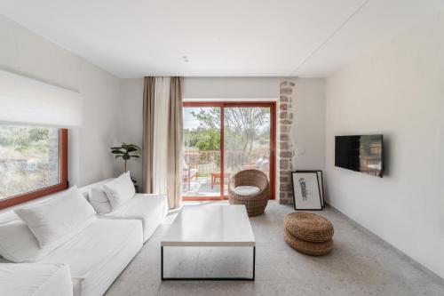 Una sala de estar con un sofá blanco y una mesa. en Kampus Luxury Villas, en Tríkala
