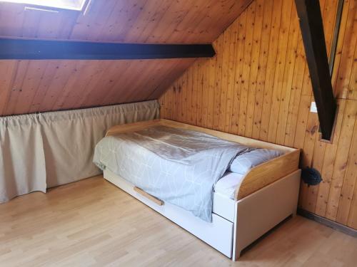 Cama en habitación con techo de madera en Studio Duplex avec jardin - La voie des Salines 