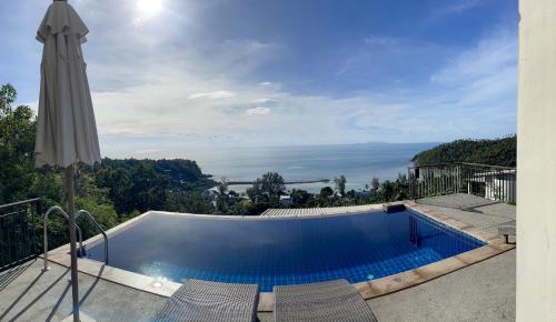 a swimming pool with chairs and an umbrella at High Life Villas in Salad Beach