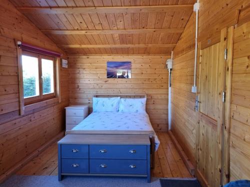 a bedroom in a log cabin with a bed at The Lodge in Sidlesham