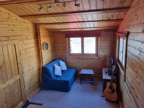 Habitación con sofá azul en una cabaña de madera en The Lodge, en Sidlesham