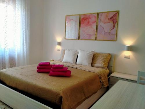 una camera da letto con un letto con due cuscini rossi sopra di Le Camelie camera a Bosa