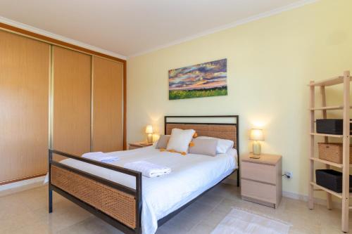 een slaapkamer met een bed en een boekenplank bij Casa Bela Vista in Carvoeiro