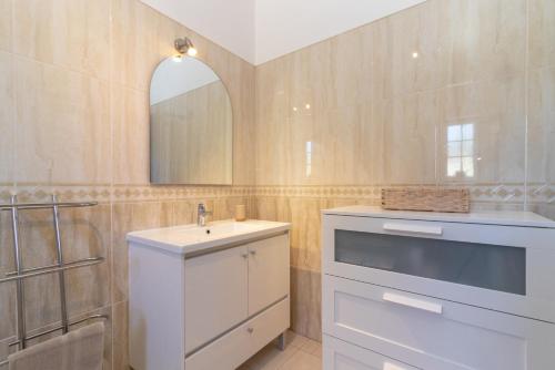 een badkamer met een wastafel en een spiegel bij Casa Bela Vista in Carvoeiro