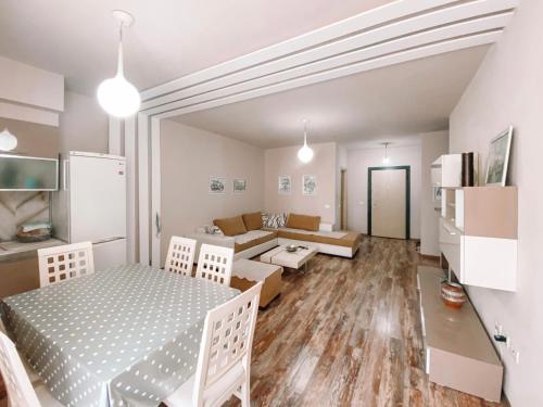 ein Wohnzimmer mit einem Tisch und einem Sofa in der Unterkunft Cozy and spacious two bedroom apartment in Shengjin in Shëngjin