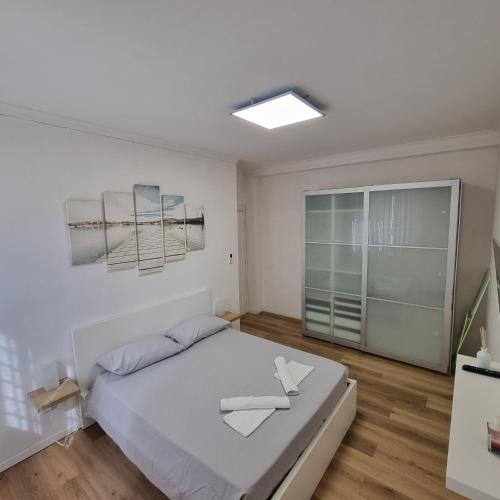 a white bedroom with a bed and a window at Dibbio's house in Guidonia