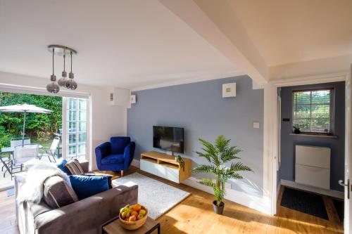 a living room with a couch and a tv at Riverwalk Apartment One in Datchet