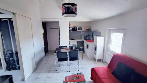 un salon avec un canapé rouge et une cuisine dans l'établissement T2 meublé Toulon côte azur - 4 personnes max, à Toulon