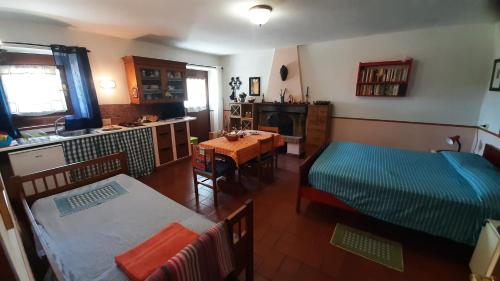 a living room with a table and a kitchen with a bed at Artenatura BeB in Terranuova Bracciolini