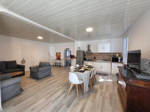 ein großes Wohnzimmer mit einem Tisch und einer Küche in der Unterkunft MAS DU RESERVOIR in Arles