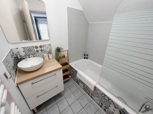 a bathroom with a sink and a tub and a toilet at Ma maison à Disneyland Paris in Magny-le-Hongre