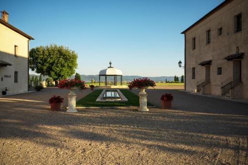 a gazebo with a fountain in the middle of a street at La Bagnaia Golf Resort in Bagnaia