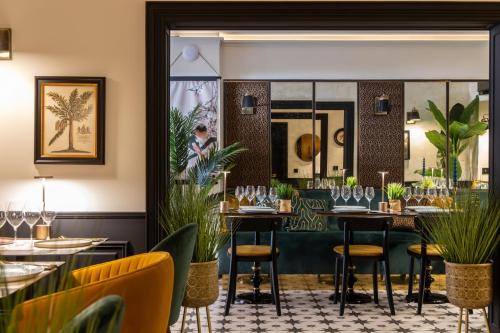 a restaurant with tables and chairs and plants at Centr'Hotel in Marigot