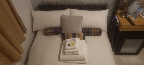 a bed with pillows and towels on it at LONDON ROOM 1 in London
