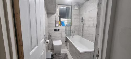 a bathroom with a tub and a toilet and a sink at LONDON ROOM 1 in London
