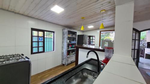 a kitchen with a sink in the middle of a room at Casa Paúba 80m do Mar in Maresias
