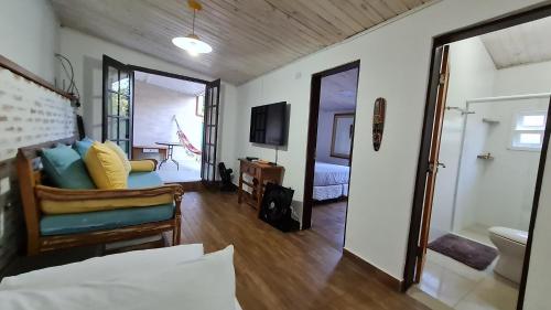 um quarto com um sofá, uma cama e uma televisão em Casa Paúba 80m do Mar em Maresias