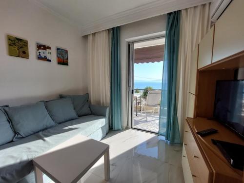 a living room with a couch and a large window at Kariani Beach Apartment in Karianí