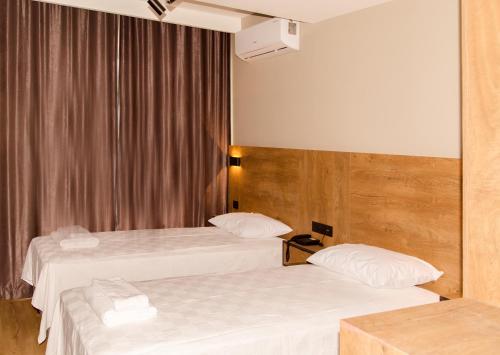 2 łóżka w pokoju hotelowym z białą pościelą w obiekcie Fidanoğlu Suite Hotel Çorlu w mieście Corlu