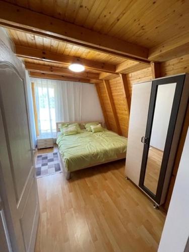 a small bedroom with a bed and a refrigerator at Corner House Zsóry Spa in Mezőkövesd